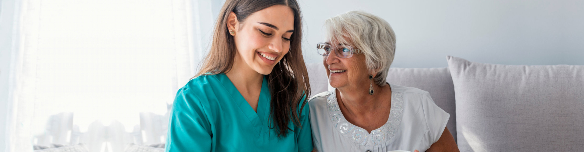 caregiver and elderly woman looking at a document